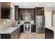 Modern kitchen with stainless steel appliances, dark cabinets, and light countertops, blending style and functionality at 15061 W 70Th Ave, Arvada, CO 80007