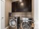 Convenient laundry room features a washer, dryer, and upper cabinets at 15061 W 70Th Ave, Arvada, CO 80007