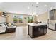 Bright living space with modern island and stainless appliances, seamlessly blending the kitchen and living areas at 15061 W 70Th Ave, Arvada, CO 80007