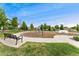 A community playground is shown with mature trees, benches, and equipment for outdoor enjoyment at 15061 W 70Th Ave, Arvada, CO 80007