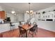 Open dining area adjacent to kitchen features wood floors, stylish chandelier, and staircase views at 11803 W Stanford Dr, Morrison, CO 80465