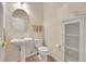 Cozy half bathroom with pedestal sink, decorative mirror and cabinet at 11803 W Stanford Dr, Morrison, CO 80465