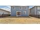 View of the back of the house with a sliding glass door and windows, overlooking a grassy backyard at 26857 E Maple Ave, Aurora, CO 80018