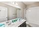 Bathroom featuring double sinks, dark cabinets, white countertops, and a tub shower combo at 26857 E Maple Ave, Aurora, CO 80018