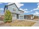 Two-story home featuring blue siding, a gray garage door, and manicured landscaping at 26857 E Maple Ave, Aurora, CO 80018