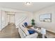 Bright living room features sleek flooring, neutral walls, and a view into the home's entry foyer and staircase at 26857 E Maple Ave, Aurora, CO 80018