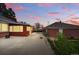 Home backyard featuring lush greenery, a brick garage, and a spacious concrete patio at 500 S Decatur St, Denver, CO 80219