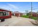 Wide backyard featuring brick garage and wooden fenced garden area, as well as a concrete patio at 500 S Decatur St, Denver, CO 80219