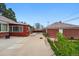 Home backyard featuring lush greenery, a brick garage, and a spacious concrete patio at 500 S Decatur St, Denver, CO 80219