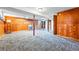 Large basement space with wood paneling, colorful carpet, and ladder lamp at 500 S Decatur St, Denver, CO 80219