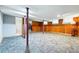 Spacious basement with retro carpet, wood-paneled walls, and exposed support beams at 500 S Decatur St, Denver, CO 80219