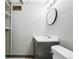 Bathroom featuring a sleek vanity with modern fixtures, a round mirror, and neutral tones at 500 S Decatur St, Denver, CO 80219