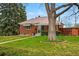 Charming brick home with a well-maintained lawn and mature tree, blending classic appeal with inviting outdoor space at 500 S Decatur St, Denver, CO 80219