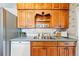 Cozy kitchen with stainless steel sink, white appliances, and warm-toned cabinetry at 500 S Decatur St, Denver, CO 80219