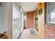 Enclosed front porch features tile flooring, large windows, and brick accent wall at 500 S Decatur St, Denver, CO 80219