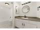 Clean bathroom featuring a combined tub and shower with a stylish vanity and round mirror at 8100 W Quincy Ave # A8, Littleton, CO 80123