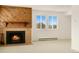 Cozy living room showcasing a brick fireplace with a wood mantle and view of the outdoors through bright windows at 8100 W Quincy Ave # A8, Littleton, CO 80123