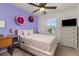 A bedroom with vibrant purple accent wall, a comfy bed, and a dedicated workspace, offering a stylish and functional space at 15446 Coopers Hawk Way, Parker, CO 80134