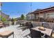 Outdoor deck featuring dining and seating areas, string lights, and a fire pit, perfect for entertaining at 15446 Coopers Hawk Way, Parker, CO 80134