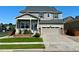 Charming two-story home featuring a landscaped front yard, covered porch, and attached two-car garage at 15446 Coopers Hawk Way, Parker, CO 80134