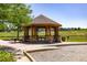 Wooden gazebo with stone accents provides a shady gathering place in a well-maintained community park at 15446 Coopers Hawk Way, Parker, CO 80134