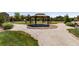 Community gazebo provides a shaded space with picnic tables and a barbecue grill in the background at 15446 Coopers Hawk Way, Parker, CO 80134