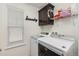 Well-organized laundry room featuring a modern washer and dryer, plus storage shelves and a window at 15446 Coopers Hawk Way, Parker, CO 80134