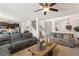 Open-concept living room featuring a ceiling fan and staircase to the second level at 15446 Coopers Hawk Way, Parker, CO 80134