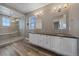 Well-lit bathroom with double vanity, mirrors, and modern glass shower at 4565 Colorado River Dr, Firestone, CO 80504