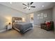 Cozy bedroom with a ceiling fan, neutral walls, and a decorative chair and lamps at 4565 Colorado River Dr, Firestone, CO 80504