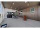 Spacious covered patio with recessed lighting, dining set, grill, and wood-paneled walls for comfortable outdoor living at 4565 Colorado River Dr, Firestone, CO 80504