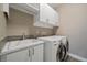 Well-equipped laundry room with modern appliances, white cabinets and sink at 4565 Colorado River Dr, Firestone, CO 80504