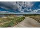 Scenic walking path winds alongside a picturesque lake, showcasing recreational opportunities and natural beauty at 4565 Colorado River Dr, Firestone, CO 80504