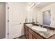 A bathroom featuring double sinks, granite counters, decorative lighting, and neutral finishes at 4807 River Highlands Loop, Elizabeth, CO 80107