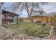 Spacious backyard with a well-maintained lawn, mature trees, and a dining area at 8985 W Quarto Pl, Littleton, CO 80128