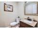 Charming half-bathroom featuring a granite countertop, ornate mirror and classic fixtures at 8985 W Quarto Pl, Littleton, CO 80128