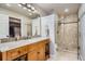 Bright bathroom featuring a granite countertop vanity, shower and tile flooring at 8985 W Quarto Pl, Littleton, CO 80128