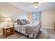 Bedroom featuring soft carpet, a queen-size bed, neutral walls, and a window for natural light at 8985 W Quarto Pl, Littleton, CO 80128
