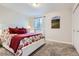 Comfortable bedroom with floral bedspread, neutral walls, soft carpet and a window for natural light at 8985 W Quarto Pl, Littleton, CO 80128