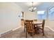 Bright dining room with wood table, carpet floors and ample natural light from a large window at 8985 W Quarto Pl, Littleton, CO 80128