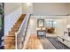 Bright foyer with hardwood floors, staircase, and open view to the formal dining room at 8985 W Quarto Pl, Littleton, CO 80128
