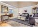 Cozy living room featuring a large rug, comfortable seating, and an open layout into the dining area at 8985 W Quarto Pl, Littleton, CO 80128