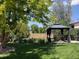 Beautiful backyard with a gazebo, lush greenery, and a well-manicured lawn at 12235 Garfield Pl, Thornton, CO 80241