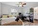 Bright bedroom featuring a ceiling fan, wood floors, a large window, and desk space at 12235 Garfield Pl, Thornton, CO 80241