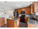 Updated kitchen with wood cabinets, stainless steel appliances, gray backsplash, and a center island at 12235 Garfield Pl, Thornton, CO 80241