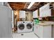 Well-lit laundry room featuring a modern washer and dryer, storage cabinets and ample counter space for folding at 12235 Garfield Pl, Thornton, CO 80241