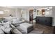 Open-concept living room with hardwood floors, neutral walls, comfortable sofas, and a view into the kitchen at 12235 Garfield Pl, Thornton, CO 80241