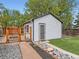 Charming backyard showcasing a shed, fenced enclosure, wooden walkway, and decorative stone accents at 4747 S Elati St, Englewood, CO 80110