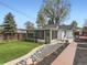 Expansive backyard with a well-kept lawn, stone accents, a screened-in porch, and inviting patio seating at 4747 S Elati St, Englewood, CO 80110