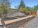 Landscaped backyard showcasing a wooden walkway, bordered by decorative rocks, leading to a fenced enclosure at 4747 S Elati St, Englewood, CO 80110